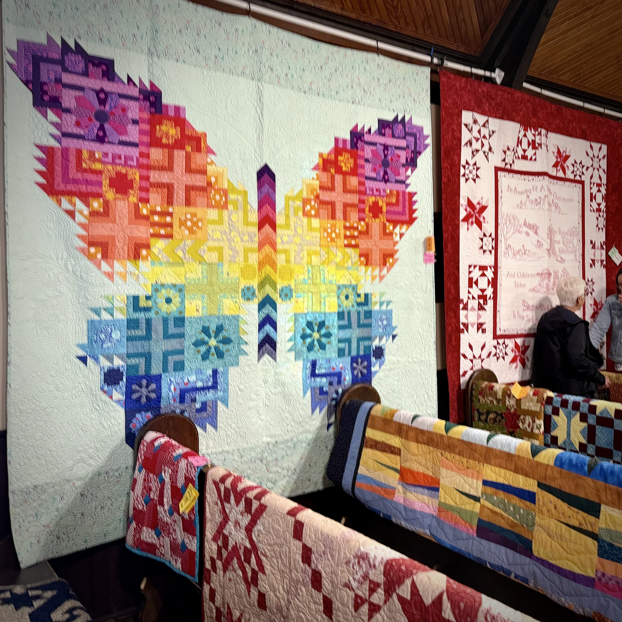 Handmade quilts with stitched fabric pieces joined together.